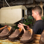 Adult,Man,Working,In,A,Shoe,Factory,,Sewing,The,Soles